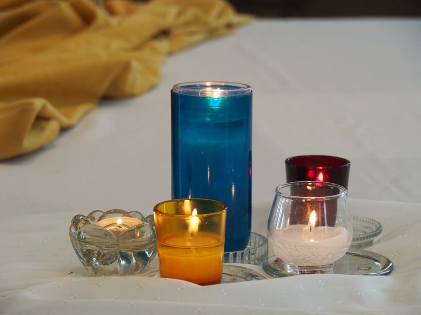 Bougies allumées sur du linge, ambiance tamisée