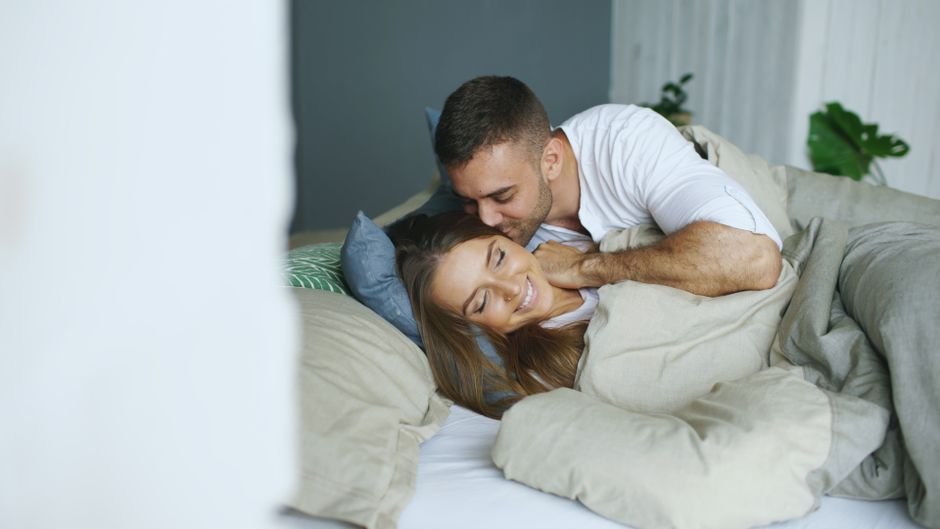 Couple câlin au lit, moment tendre après l’amour