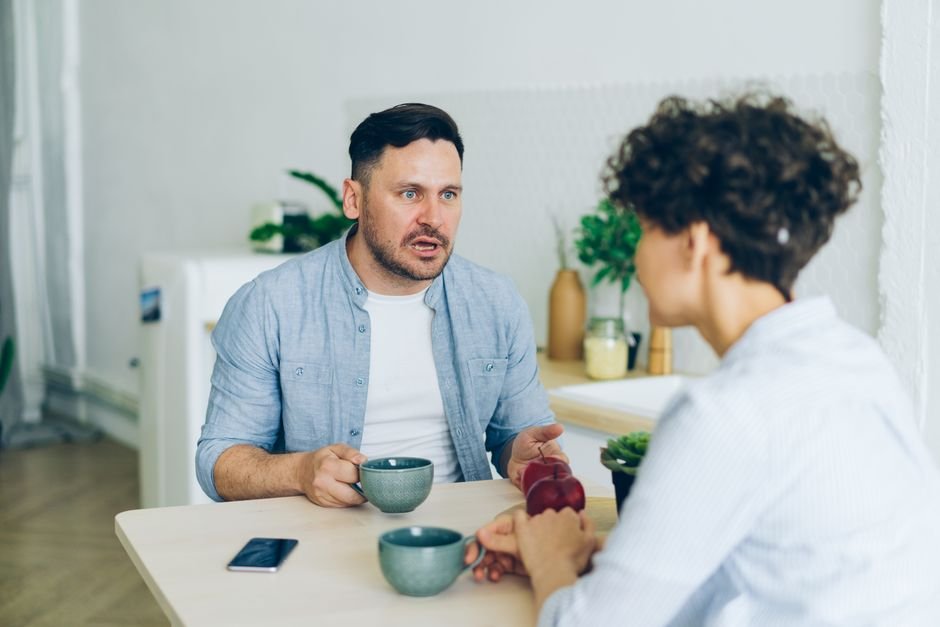 Couple en pleine conversation sérieuse autour d'une tasse de café