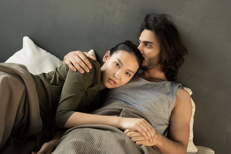 Couple enlacé et complice dans un lit