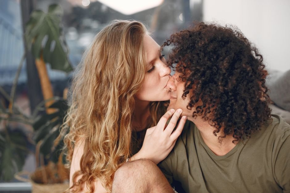 Couple partageant un baiser tendre dans un intérieur cosy