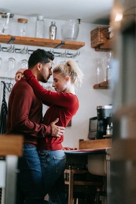 Couple partageant un moment de tendresse spontané dans un intérieur moderne