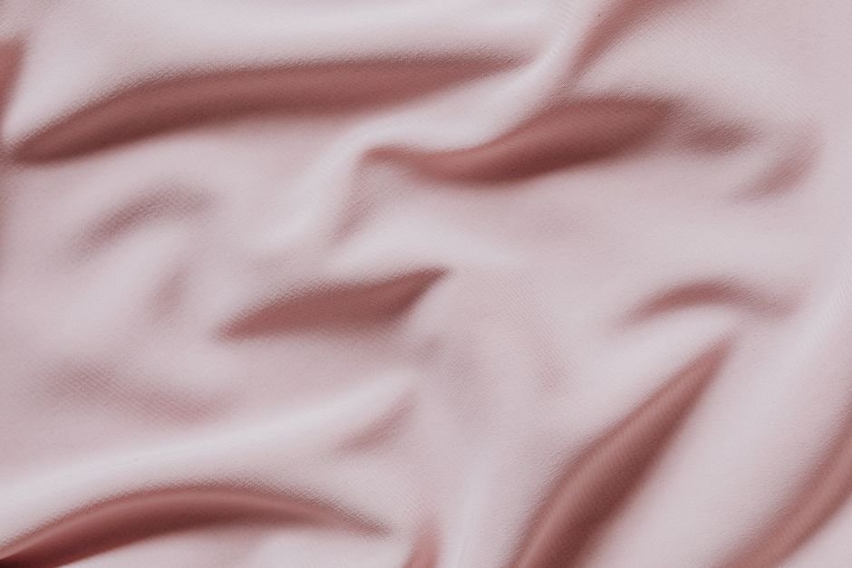 Drapé de tissu rose satiné évoquant la douceur
