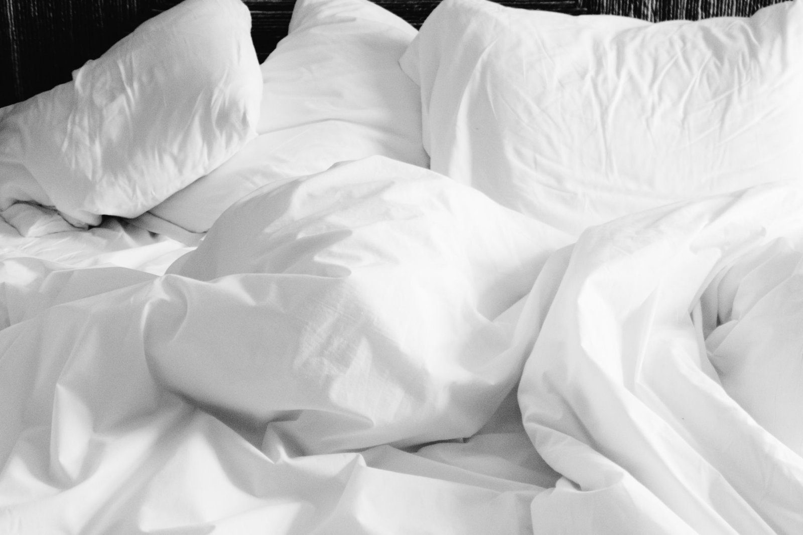 Draps blancs froissés sur un lit