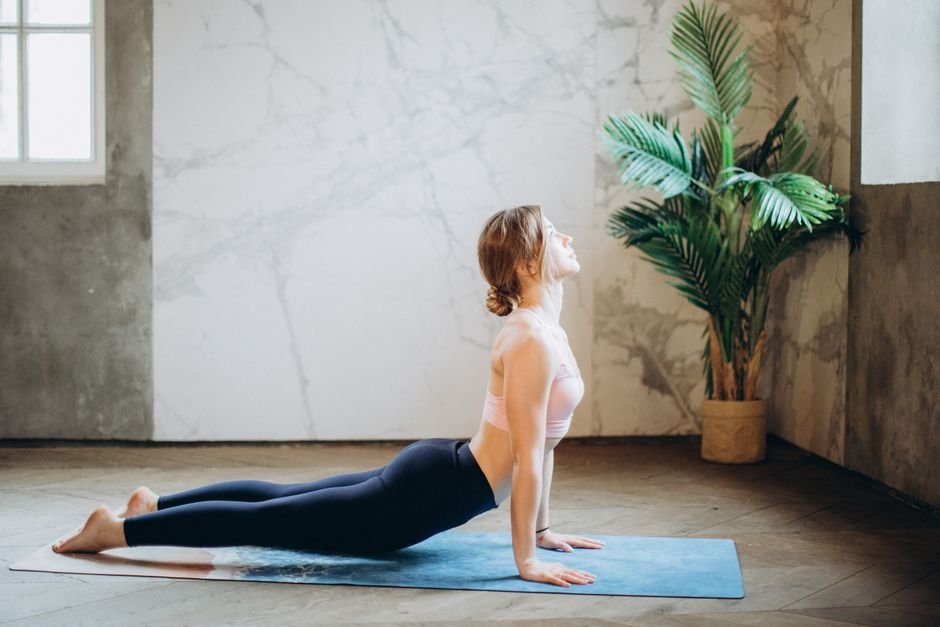 Femme en tenue de sport sur un tapis, pratiquant un exercice de renforcement du plancher pelvien