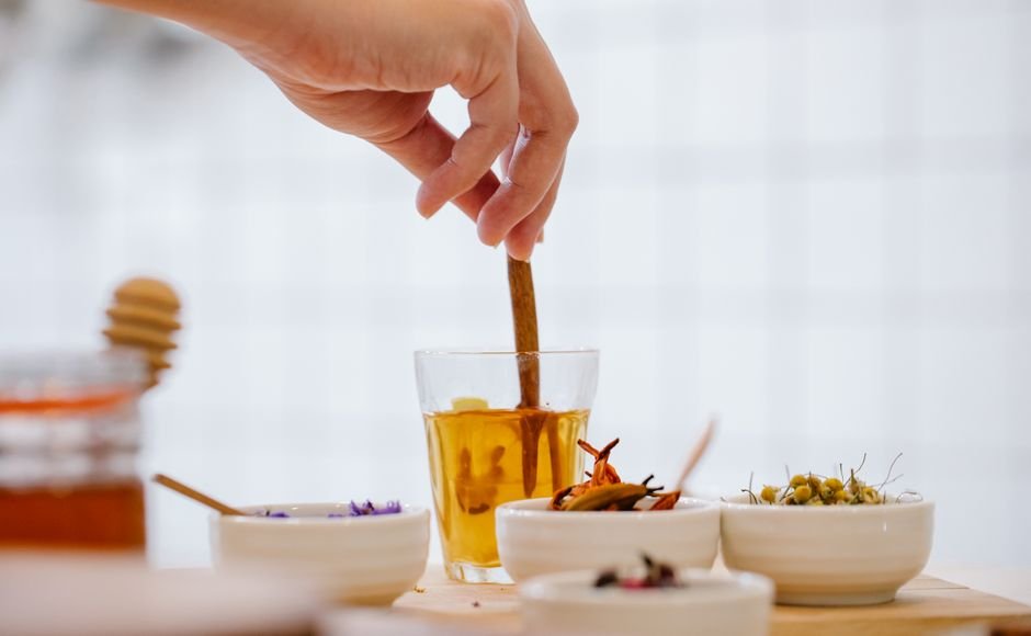 Mains préparant une tisane aux épices