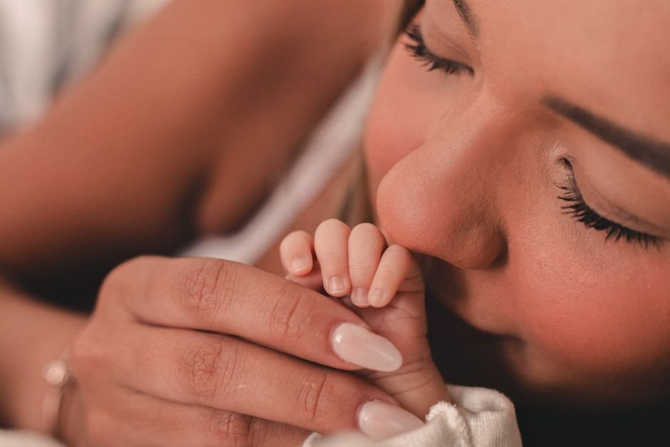 Mère embrassant la main de son nouveau-né