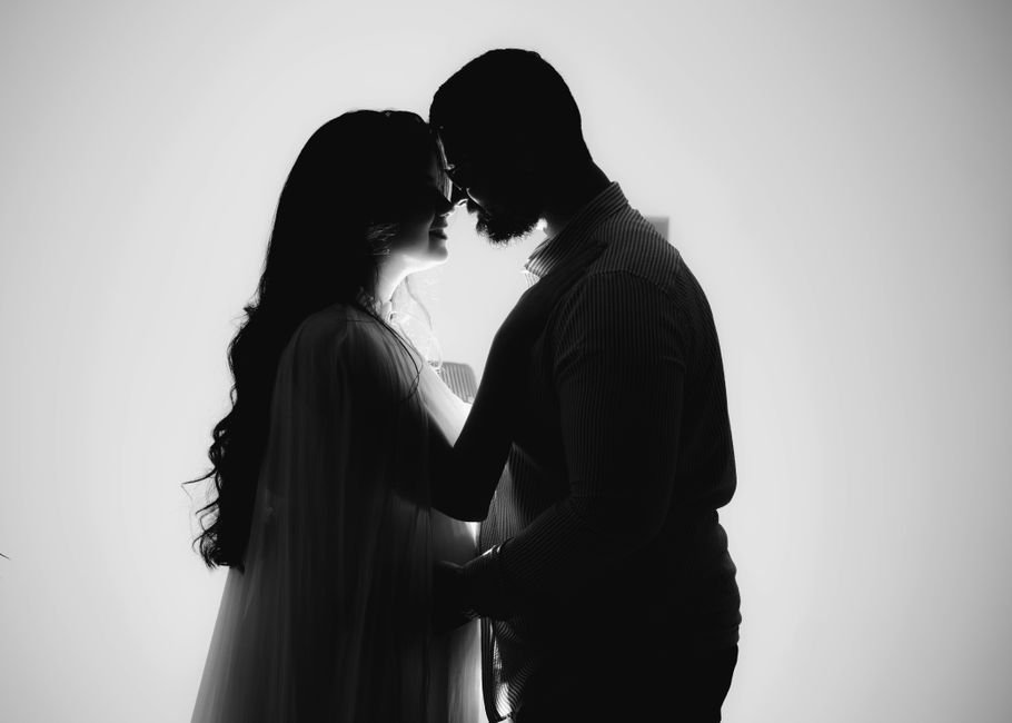 Silhouette d’un couple enlacé à contre-jour, front contre front